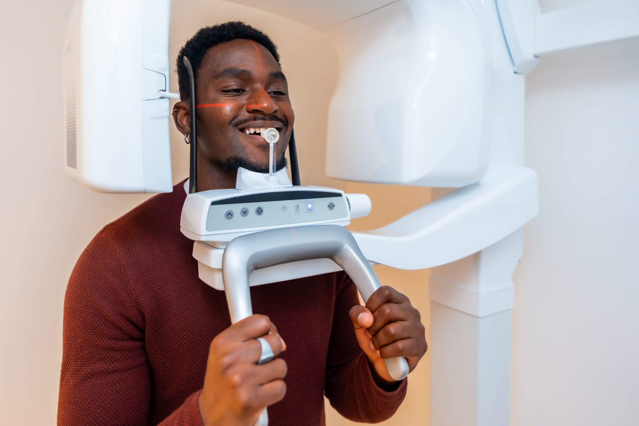 Patient smiles while undergoing a dental x ray scan in a modern dental clinic, demonstrating advanced oral healthcare technology