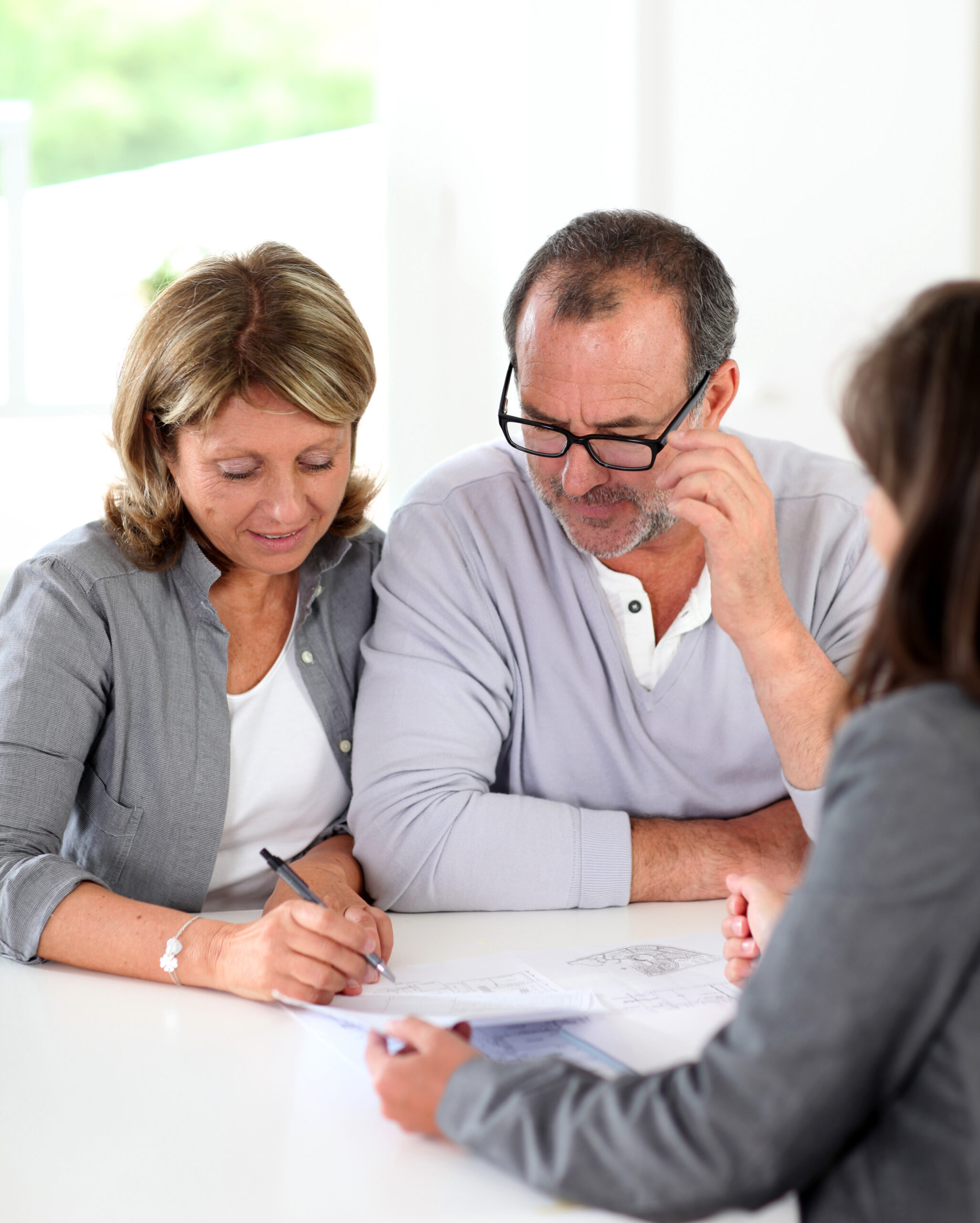Senior couple signing financial contract