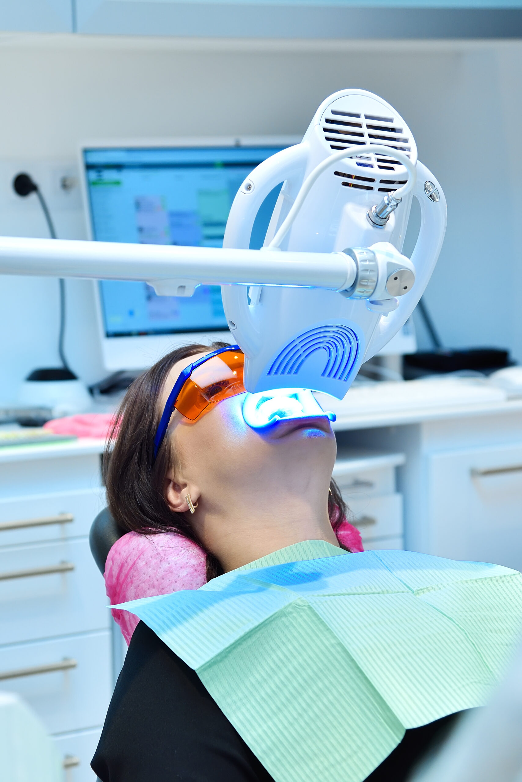 Teeth whitening procedure with ultraviolet light lamp. Dental and teeth whitening concept. Close up