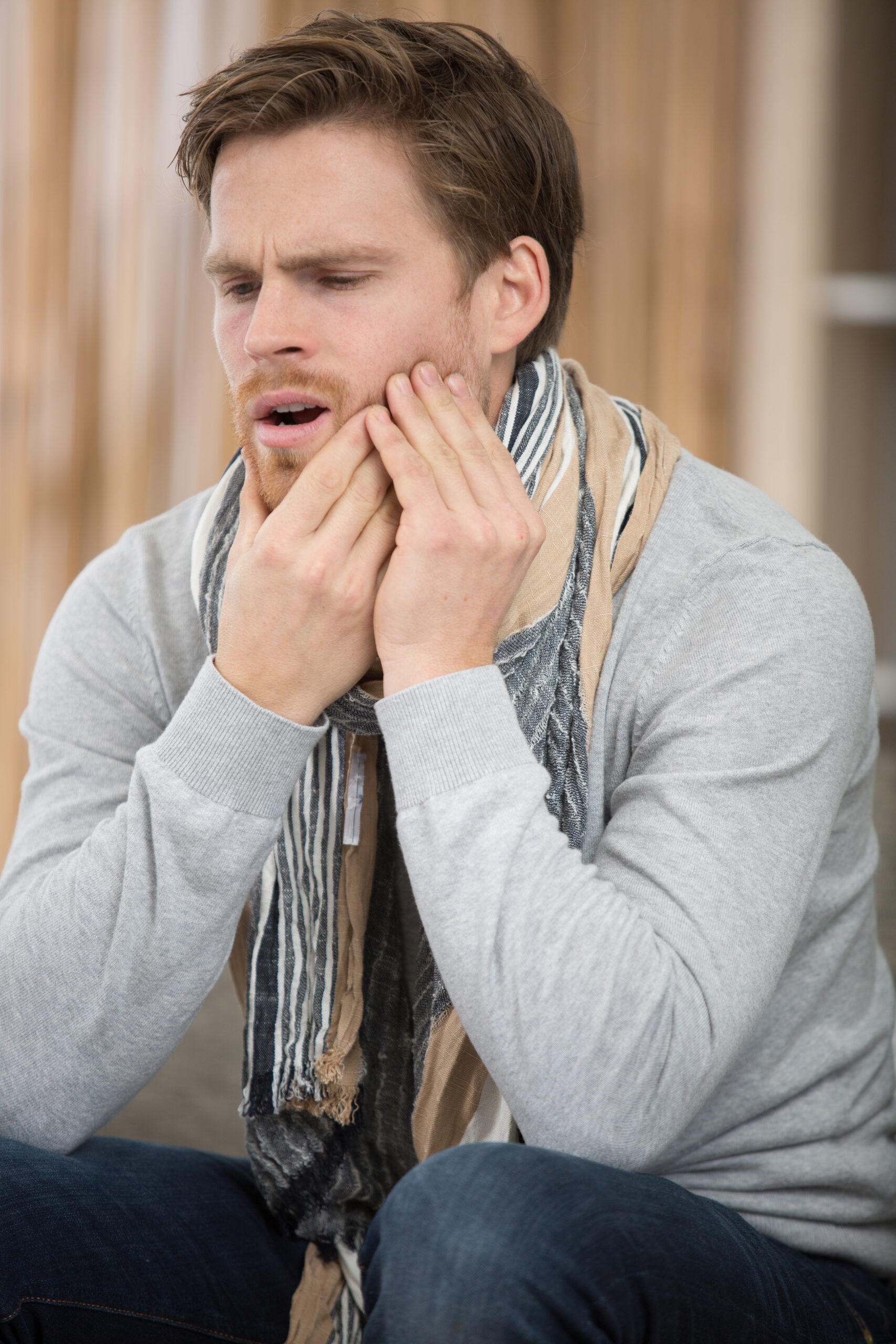 man holds his hand near the cheek toothache