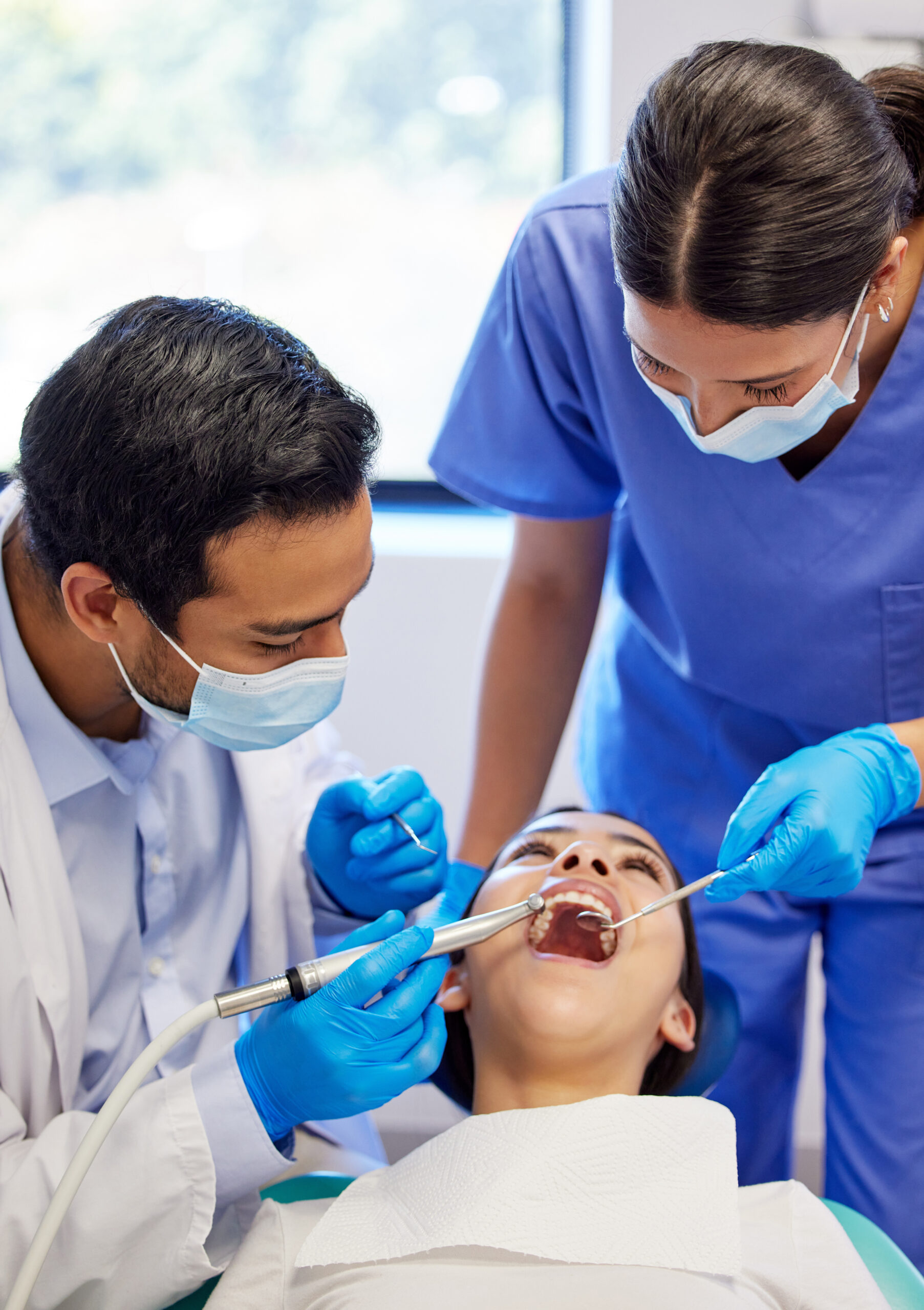 Dentist, oral care and procedure with patient for healthcare, wellness and teeth whitening in practice. Woman, ppe and dental professional with tools for consultation, cleaning and filling on chair.